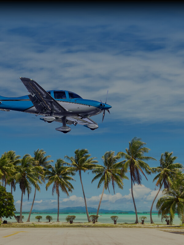 Cirrus aircraft landing near a tropical beach