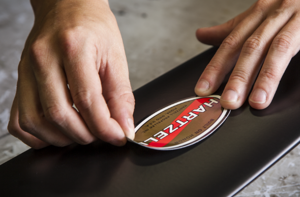 Hand applying Hartzell label on a propeller blade